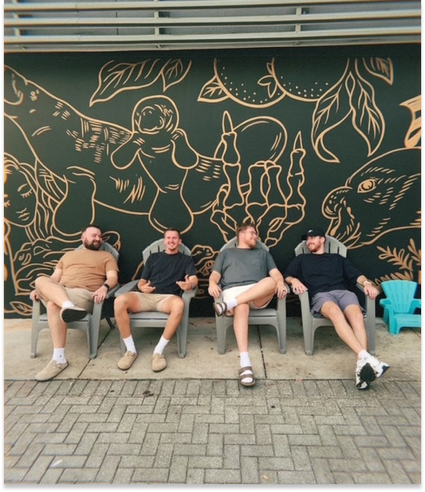 Zach and friends sitting in front of a Florida wildlife mural