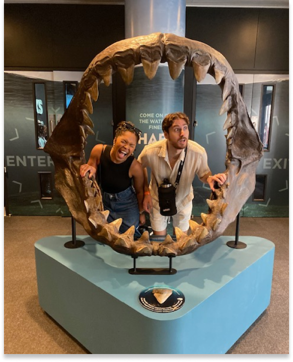 Zach and his wife posing inside a megalodon jaw exhibit